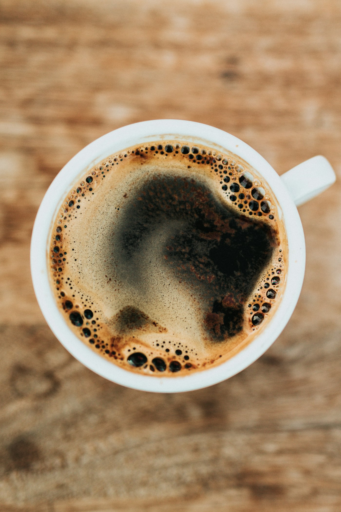 Mug of hot cocoa with whipped cream on a rustic table